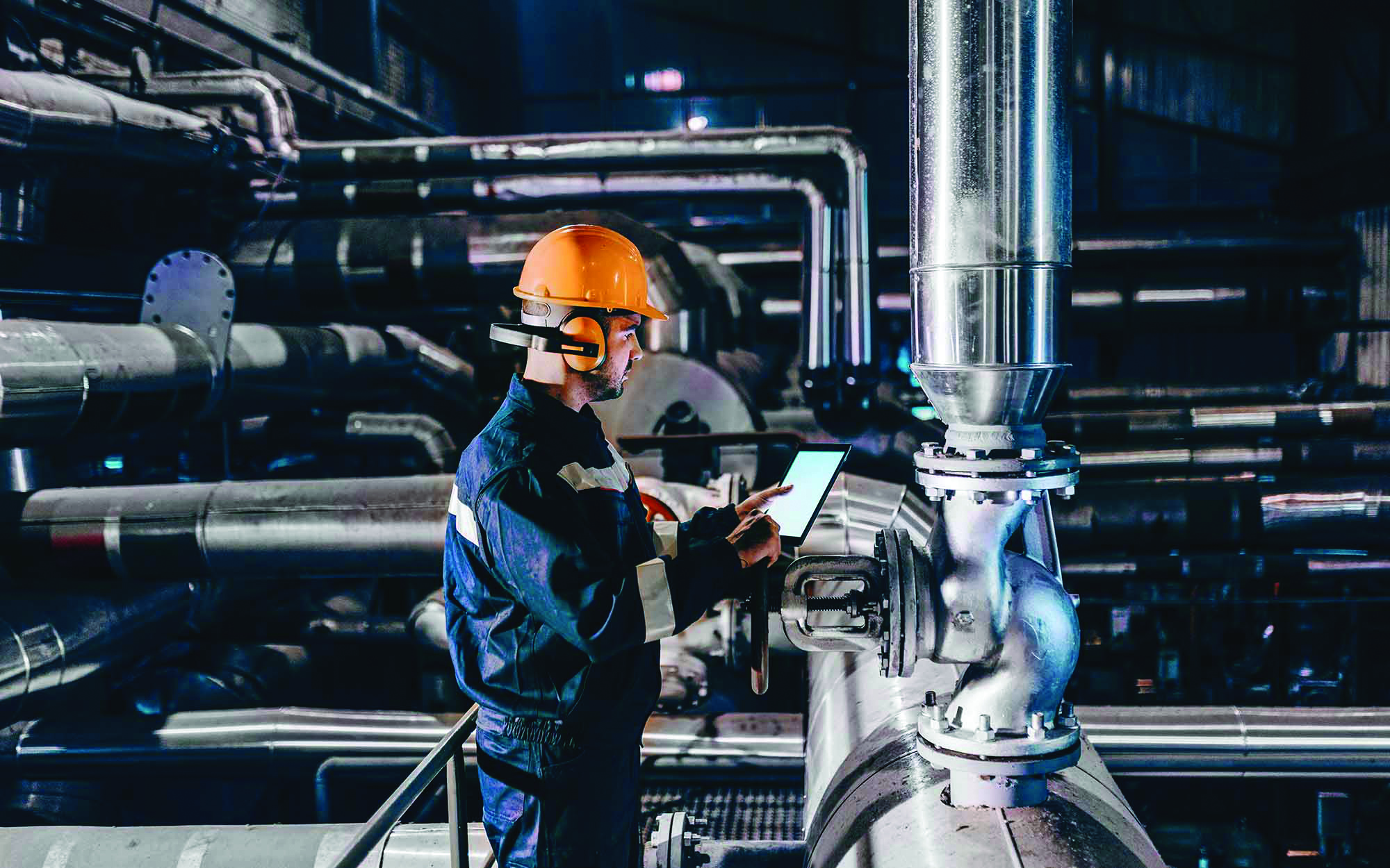 Side-view-of-worker-looking-over-stats-on-tablet