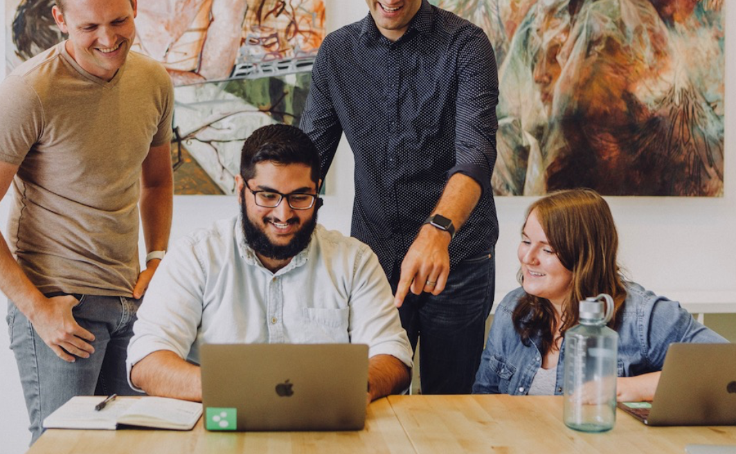 Group of people sharing a laptop screen